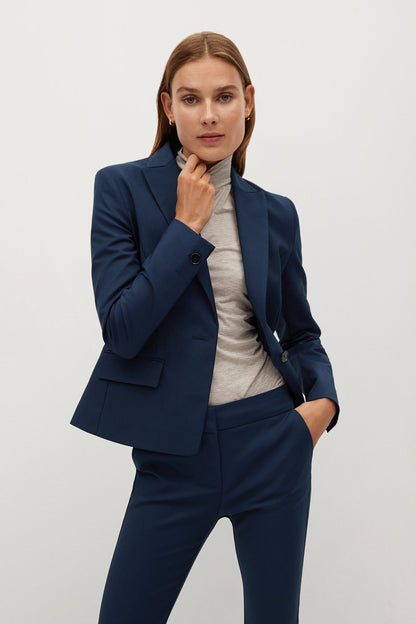 Navy tailored blazer with notch lapel and welt pockets, worn with slim trousers