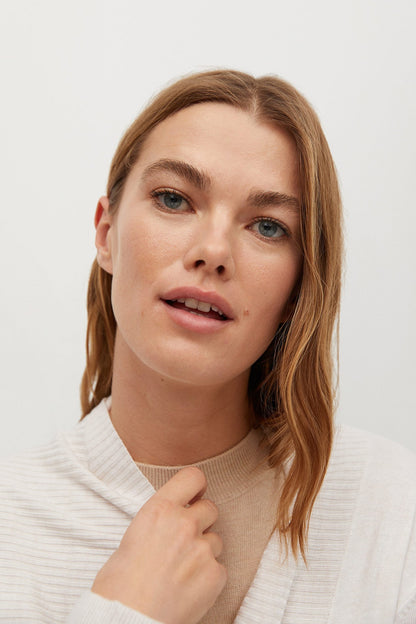 Ecru knit cardigan close-up with ribbed texture and front tie detail