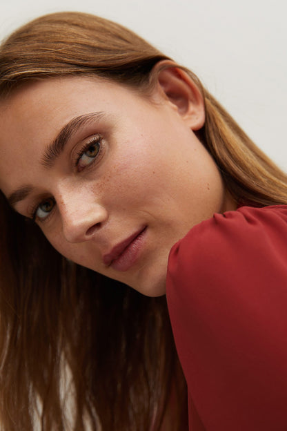 Red blouse with tie neckline detail and wide shoulder cuff