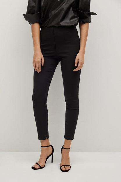 Black skinny trousers with ankle hem and black high-heel sandals, close-up