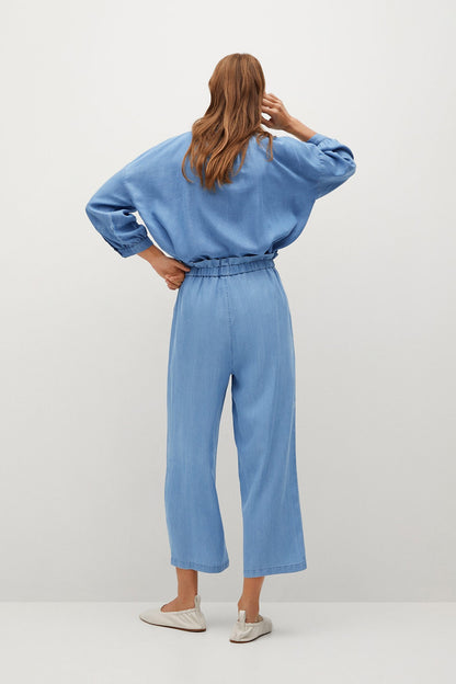 Light blue jumpsuit shown from back: long sleeves, elastic waist, cropped wide legs