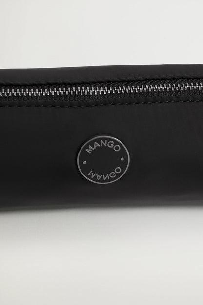 Black zip pouch close-up of round logo patch and metal zipper teeth