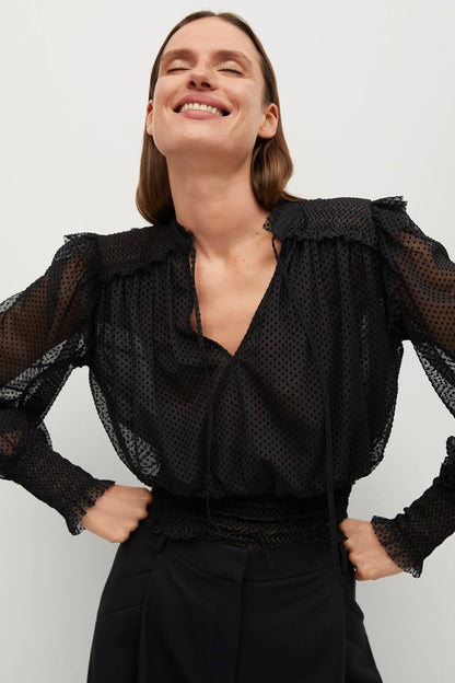 Black sheer dotted blouse with ruffle shoulders, long sleeves, and V-neck