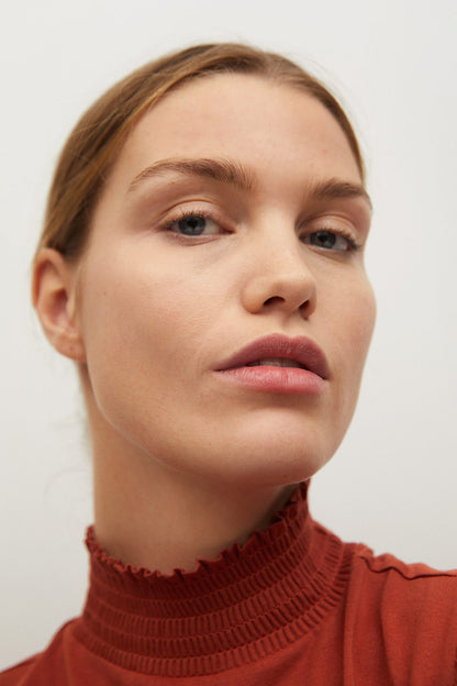 Rust orange ribbed knit turtleneck top neckline, close-up