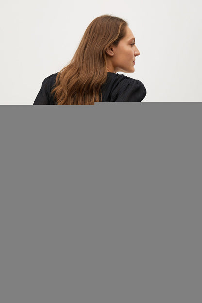 Black puff-sleeve blouse with gathered back detail, side view