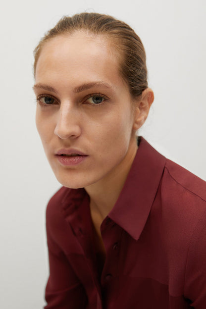 Burgundy button-up shirt close-up with pointed collar and visible buttons
