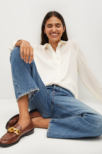 Ecru long-sleeve button-up shirt worn with rolled sleeves and open collar