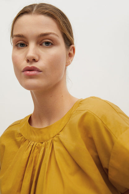 Mustard yellow gathered-neck blouse with pleated yoke detail close-up