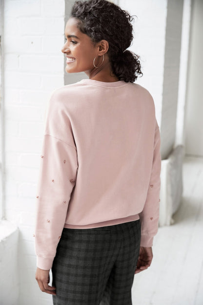 Pink crewneck sweatshirt, side view, long sleeves