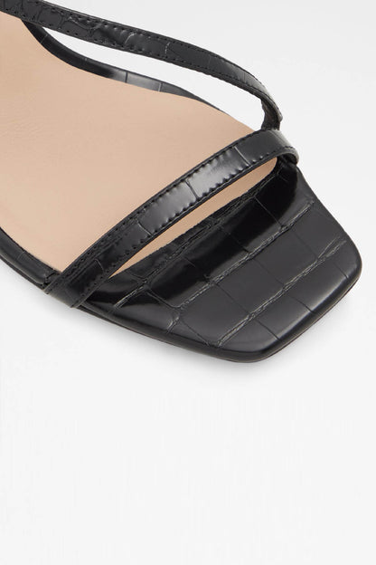 Black sandal upper close-up with crisscross strap and buckle