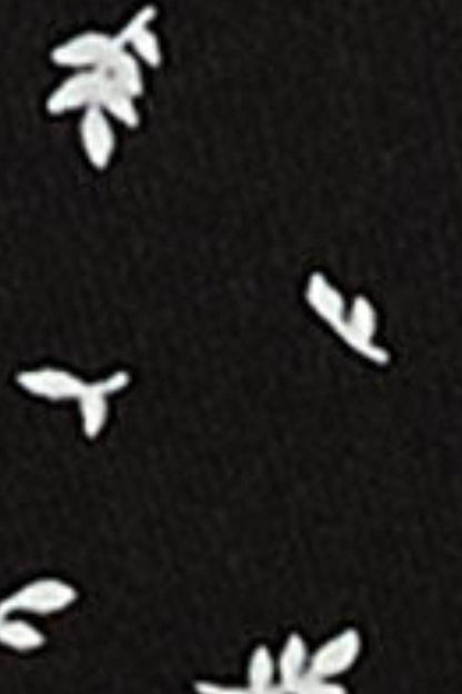 Black fabric close-up with small white bow-like motifs