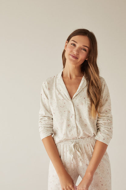 Women's pajama set, cream-colored button-up top and matching elastic-waist pants with print