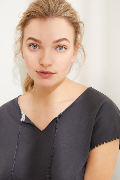Charcoal grey V-neck pajama top with short sleeves and decorative trim, close-up