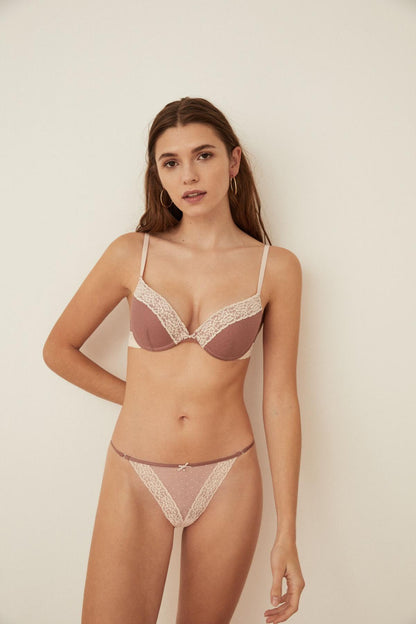 Pink lace underwire bra and thong set worn by model, adjustable straps and scalloped trim