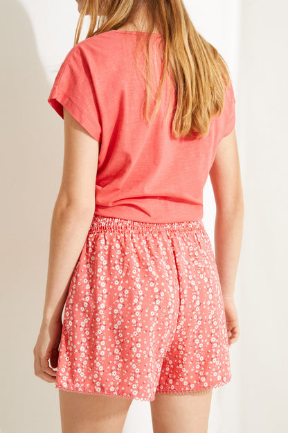 Coral pink short-sleeve top and red patterned ruched shorts, tie front