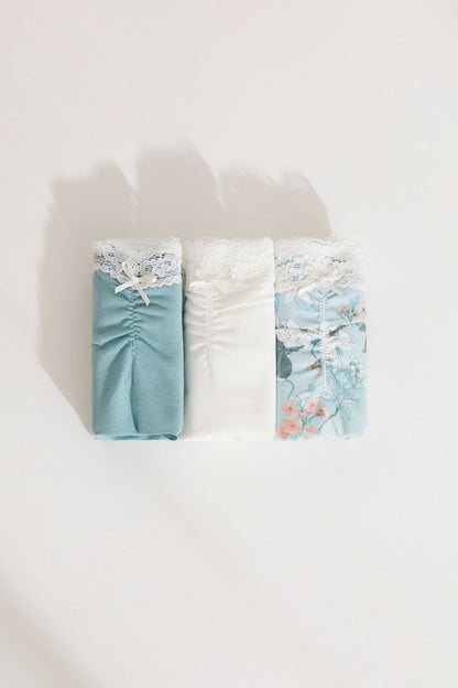 Two-pack bikini briefs: teal solid and white floral, lace trim at waistband and legs