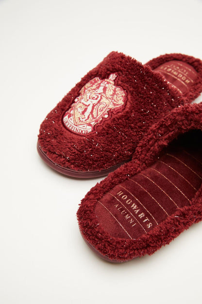 Dark red fuzzy slippers with embroidered crest patch and contrast insole text