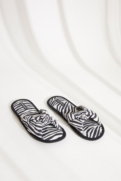 Pair of zebra-print slip-on slippers with knotted bow strap and dark edges
