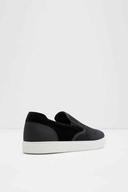 Black slip-on sneakers angled side view, soft upper and white rubber sole