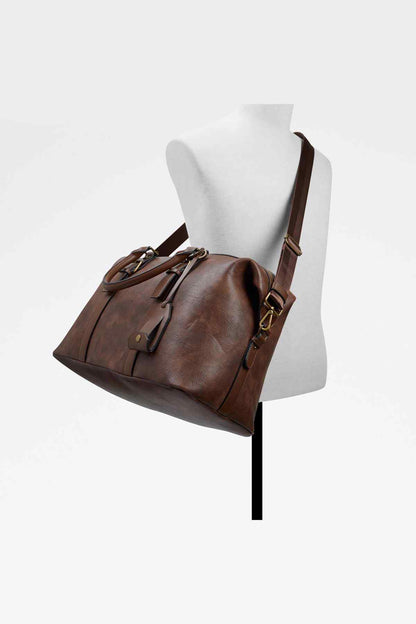 Brown leather duffel bag on mannequin with shoulder strap and top handles