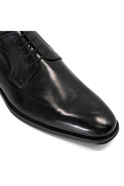 Black leather oxford shoe close-up, lace-up front and stitched welt sole