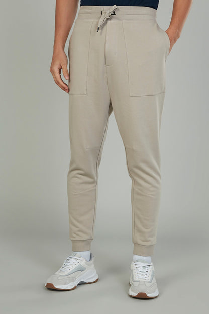 Cream drawstring jogger pants with side pockets and cuffed hems