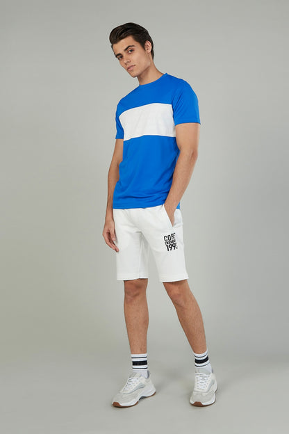White knee-length drawstring shorts with logo print on right leg