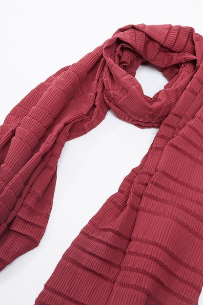 Burgundy textured scarf with pleated stripe pattern, draped with loose ends