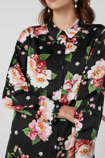 Black floral button-up blouse close-up with pink roses, green leaves, long sleeves