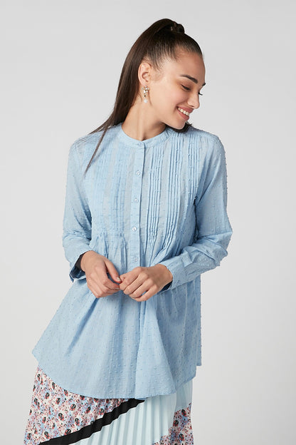 Light blue long-sleeve tunic with pintuck details, round neckline, floral hem trim