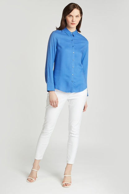 Blue button-up shirt with long sleeves, collar, and white pants