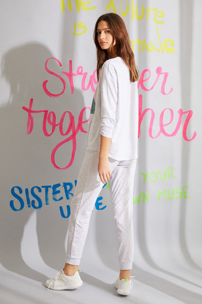 Light grey long-sleeve jumpsuit, side view; drawstring waist and cuffed jogger pants