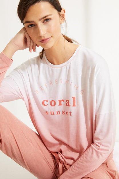 Women's pink long-sleeve lounge top with coral sunset graphic and crew neck.